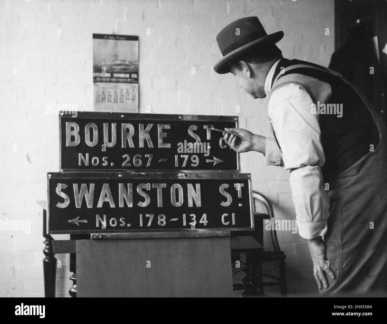 Nouvelle idée pour City Corners -- des plaques de noms comme celles-ci seront placées à 500 intersections de ville les plaques d'essai, montrées ici recevant des touches finales aujourd'hui, sont un succès au coin des rues Bourke et Swanston. Les noms et numéros de rue sont en relief en aluminium sur fond noir. 27 juin 1938. Banque D'Images