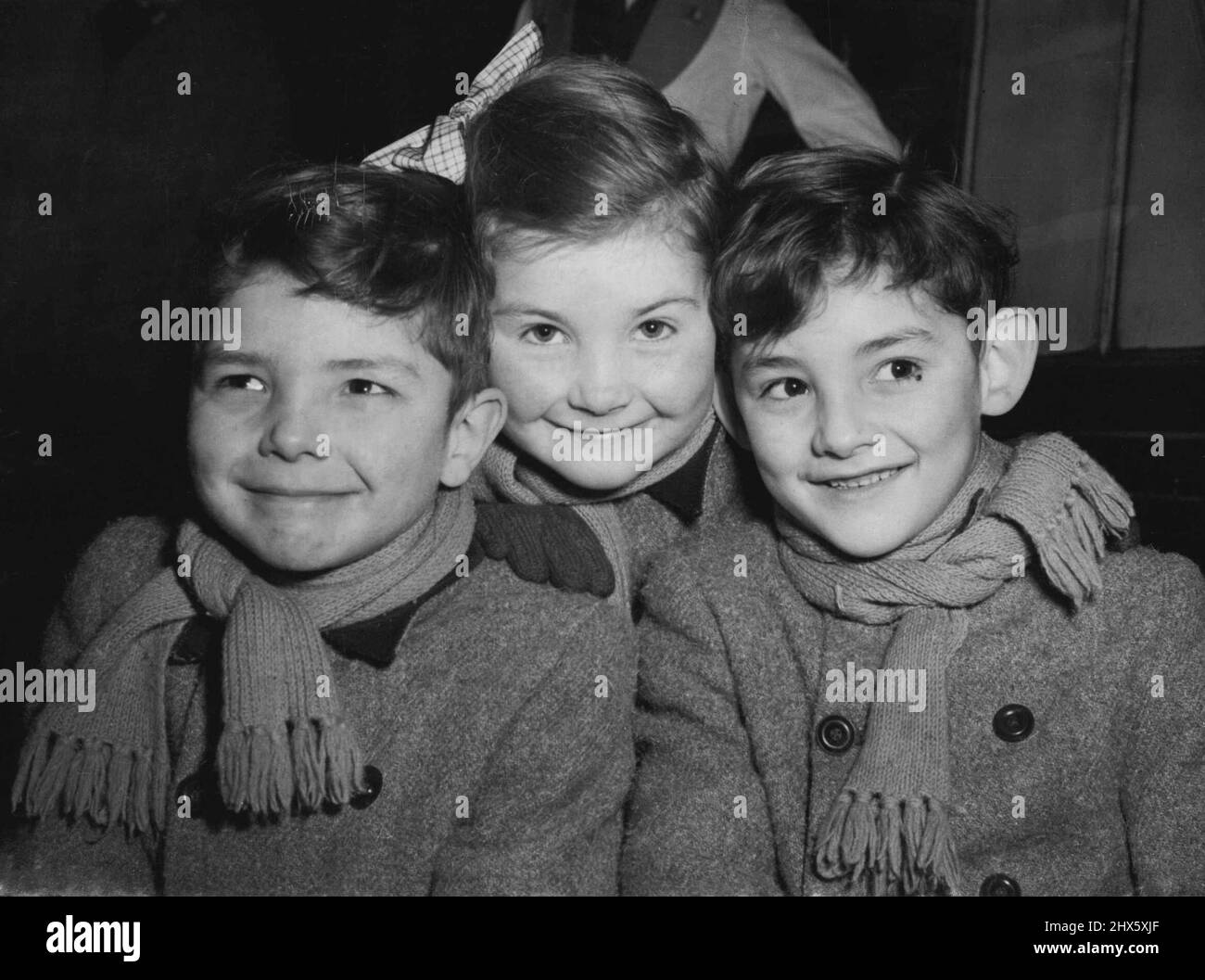 Les « triplés de Kenton » vont en Tasmanie -- trois jeunes migrants, les triplés de Tonelly, âgés de sept ans (de gauche à droite) Paul, Julia et Peter - photographiés à la gare de Waterloo, Londres, avant d'embarquer aujourd'hui dans le train à bateaux « Malaja » pour l'Australie (jeudi). Né il y a sept ans à la Saint-Valentin, ils viennent de Kenton, Middlesex, et vont avec leurs parents s'installer dans le nord de la Tasmanie. M. Walter Tonelly, le père, a été le maître de bétail du comte de Wilton, à Woodstock, à Oxford. Il le fera Banque D'Images