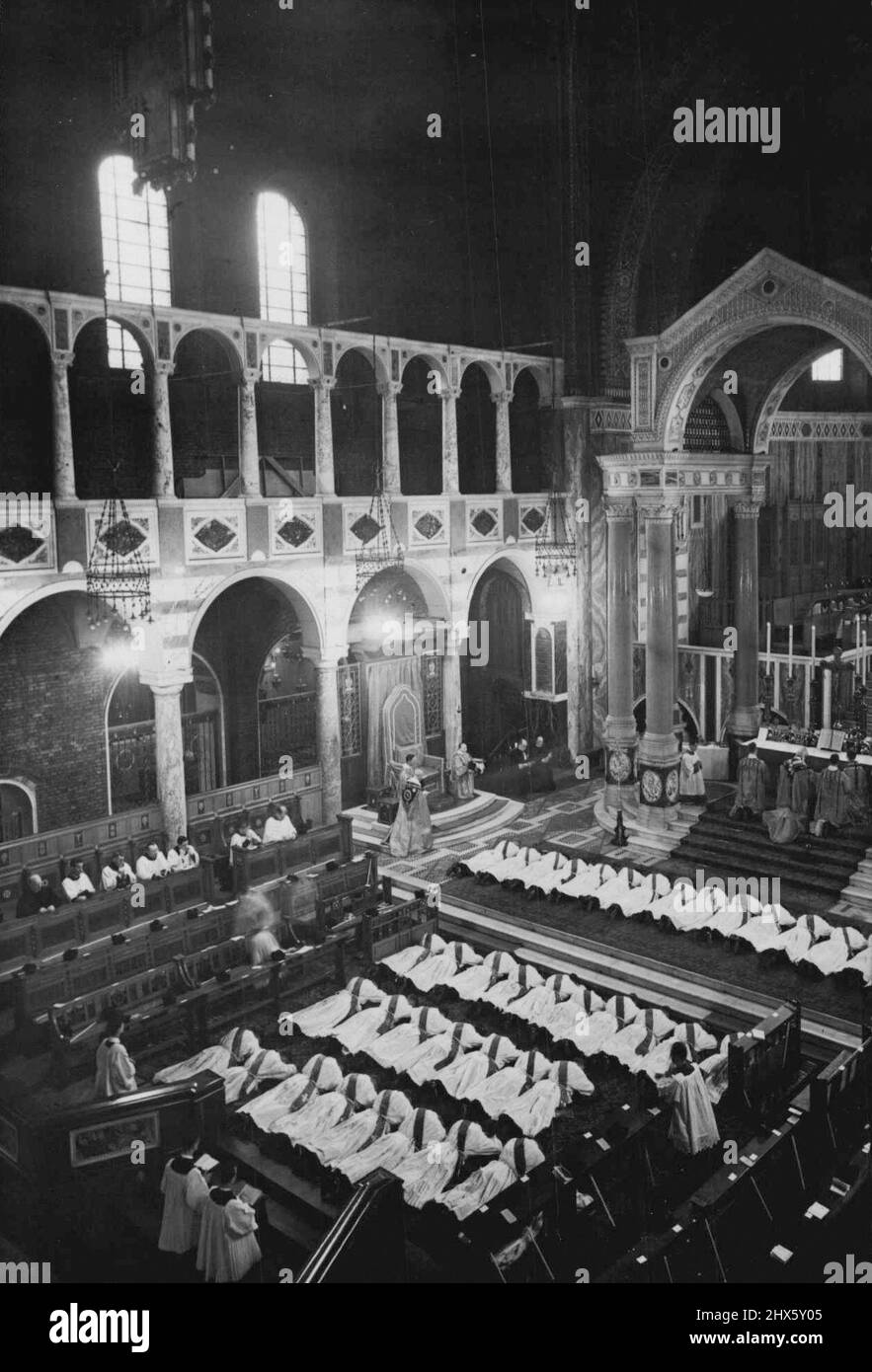 Ordination de quarante-cinq prêtres - la scène à l'intérieur de la cathédrale de Westminster pendant la cérémonie d'ordination montrant les nouveaux prêtres qui se trouvent se promènent devant l'autel. Le cardinal Hinsley est à genoux sur l'autel (au centre). Quarante-cinq prêtres ont été ordonnés à un service d'ordination à la cathédrale de Westminster, à Londres, ce matin. Les nouveaux prêtres doivent poursuivre leur travail dans toutes les parties du monde. C'est le plus grand nombre de prêtres ordonnés à un moment donné depuis la réforme. 9 juillet 1938. (Photo Banque D'Images