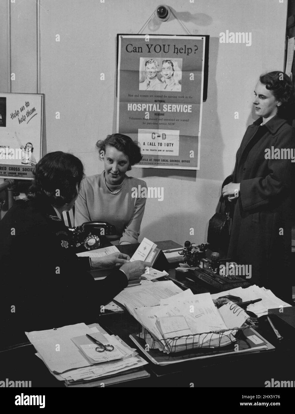 La Grande-Bretagne se tourne vers sa défense civile. Une nouvelle entrée de réserve d'hôpital à la réserve d'hôpital national obtenue par l'entremise de deux organismes d'inscription - la Brigade d'ambulance de St. John's et la Société de la Croix-Rouge britannique. Ici, un jeune volontaire est vu interviewé par un membre de la Société de la Croix-Rouge britannique. 16 juillet 1951. (Photo de British Official Photograph).;la Grande-Bretagne se tourne vers sa défense civile. Une nouvelle entrée de réserve d'hôpital à la réserve d'hôpital national dans obtenu par deux inscription o Banque D'Images