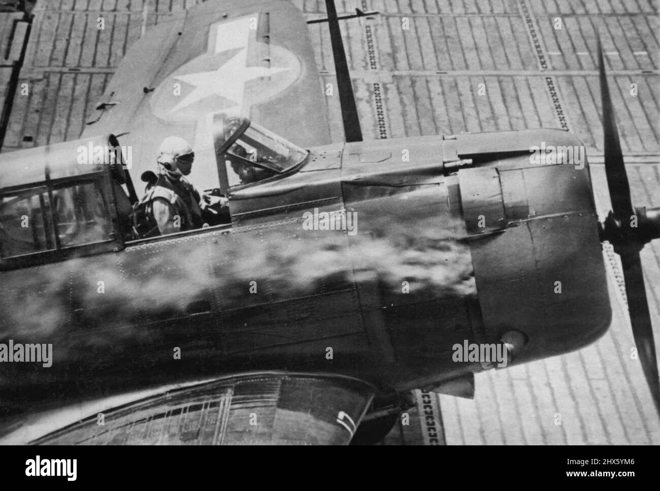 Engine Afire, U.S. plane recherches sécurité -- l'une des grandes forces de l'avion américain de base de transporteur qui a frappé la base de Jap New Britain de Rabaul novembre 11 atterrit sur le pont d'un transporteur avec son moteur en fureur d'un coup de Jap. 26 novembre 1943. (Photo par photo de presse associée). ;Engine Afire, U.S. plane recherches sécurité -- l'une des grandes forces de l'avion américain de base de transporteur qui a frappé la base de Jap New Britain de Rabaul novembre 11 atterrit sur un pont de transporteur avec son moteur en fureur d'un coup de Jap. Banque D'Images