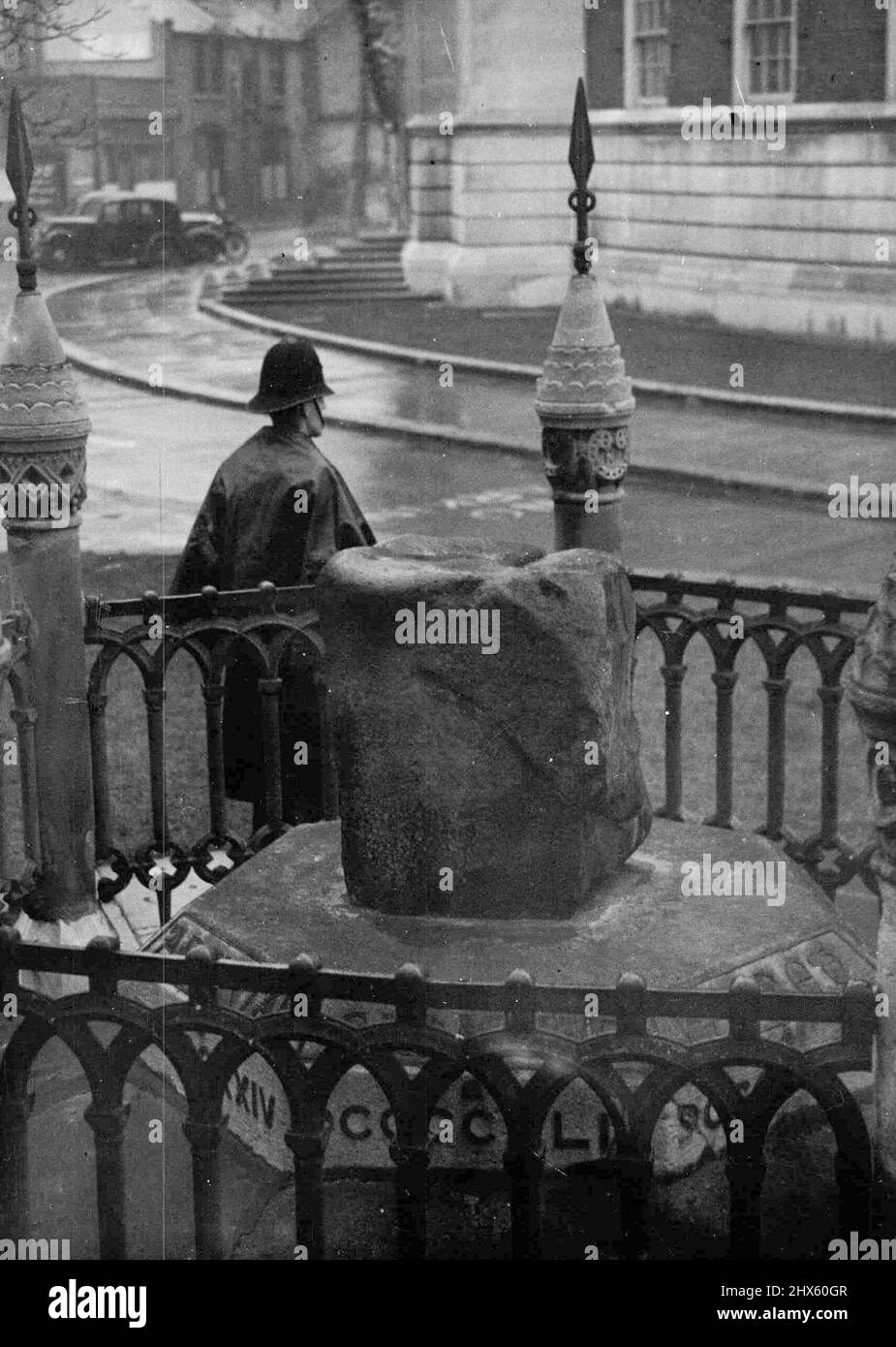 Il garde une autre pierre du Couronnement - Un gendarme de police ici a besoin de regarder au-dessus de la Pierre du Couronnement saxon (en premier plan) à Kingston-on-Thames (près de Londres). Le policier a été mis en garde après le vol de la pierre de couronnement scone à l'abbaye de Westminster le jour de Noël. Les nationalistes écossais ont menacé en mars dernier de retirer la Pierre du Coronation Saxon et de la tenir pour rançon contre le retour de la Pierre de l'abbaye, qui, selon la police, ont maintenant volé. 28 décembre 1950. (Photo par associé Banque D'Images