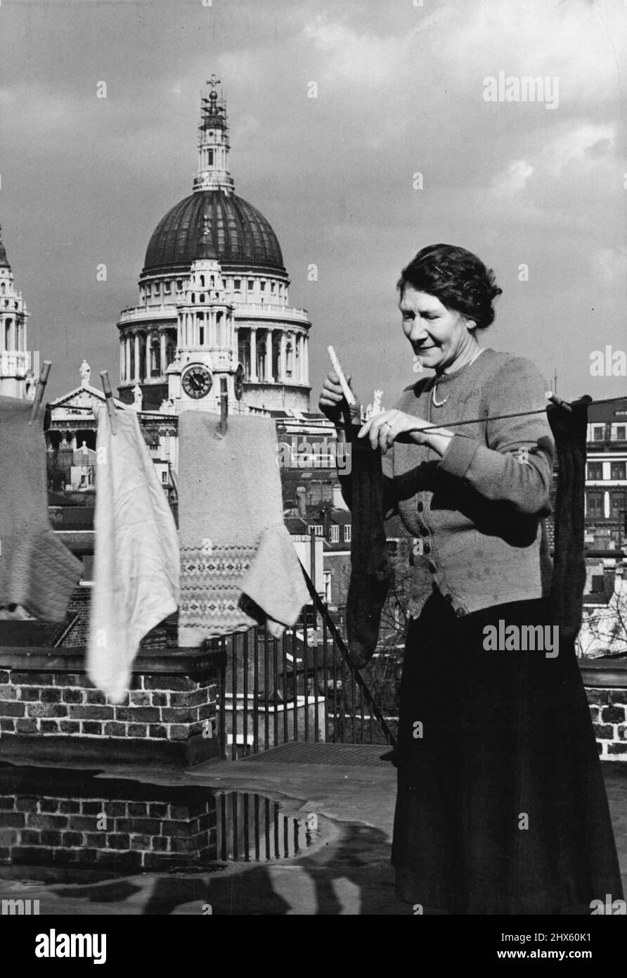 Prendre une ligne sur St. Paul's Mme Smith de New Bridge Street, City of London, peut obtenir une ligne sur St. Paul's Cathedral quand elle veut. Quand elle fait ses mains pour se laver sur le toit dans lequel elle vit, St. Pauls s'adapte sur la ligne comme ceci. 17 avril 1951. (Photo de Fox photos).;obtenir Une ligne sur St. Paul's Mme Smith de New Bridge Street, ville de Londres, peut obtenir une ligne sur St. Paul's Cathedral quand elle le veut. Lorsqu'elle se lave sur le toit dans lequel elle vit, Banque D'Images