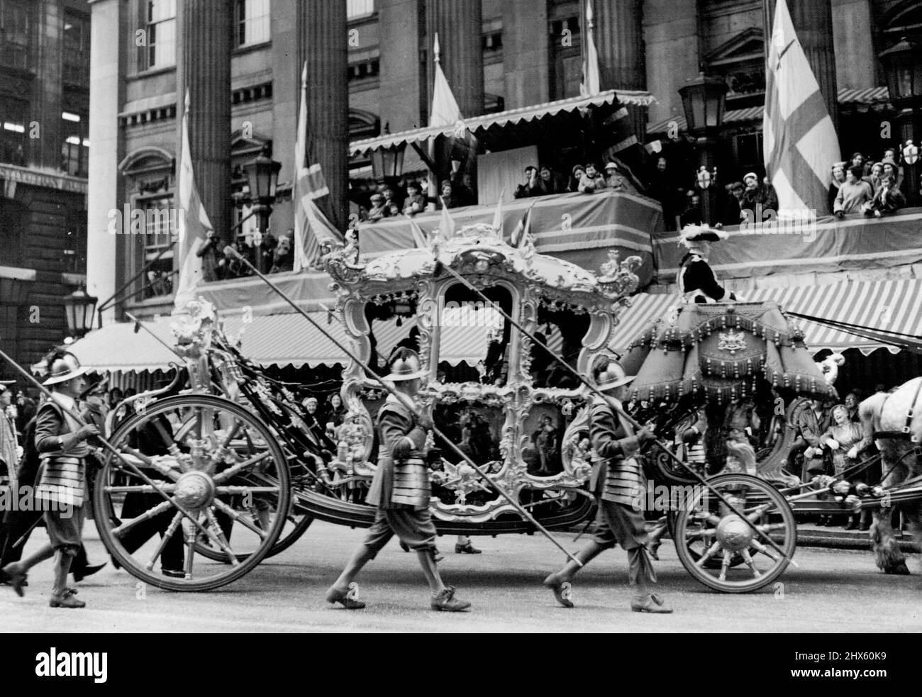 Le Lord Mayor Show de 1955 -- le nouveau Lord Mayor de Londres M. Alderman Cuthbert Ackroyd vu dans son entraîneur passant devant le Mansion He Law courts ce matin, la Lady Mayoress (Mme Ackroyd) peut être vu en agitant depuis le (centre droit dans le manteau de fourrure). Le spectacle annuel de Lord Mayor, avec ses processions traditionnelles de bandes, de chars colorés, de tableaux, etc. À travers les rues de la ville, a lieu aujourd'hui à Londres. Cela marque la conduite dans l'état du maire de Lard nouvellement élu Alderman Cuthbert Ackroyd, à Banque D'Images