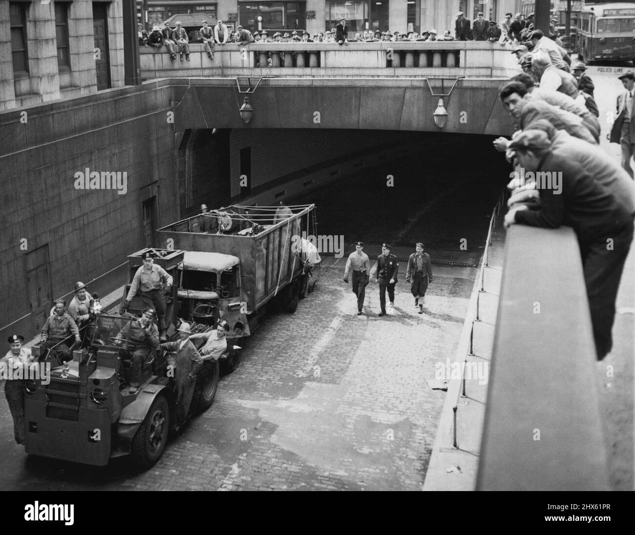 Transporter le camion de démolition du tunnel. Un véhicule de l'autorité portuaire de New York transporte un camion depuis l'entrée de Manhattan du tunnel Holland à New York, en mai 13. Plus tôt, une explosion de fûts de produits chimiques sur un autre chariot a fait un incendie qui s'est propagé à d'autres chariots dans le tunnel sous l'eau. Le capitaine Philip N. Edwards, directeur général des tunnels et des ponts de l'Administration, a déclaré à la fin de mai 13 qu'il n'y a aucune chance que le tunnel de New York soit rouvert ce soir. Onze camions ont été endommagés dans le Banque D'Images