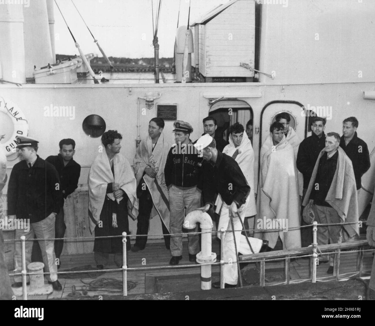 Survivants du sous-marin submergé -- montré sur la voie du Cutter Harriet de la Garde côtière aux deux premiers groupes de survivants amenés à la surface du sous-marin submergé Squalus, mai 24, au moyen d'une cloche de plongée. Héros de la catastrophe de Squalus, Lloyd Maness (au centre), raconte à Gerald McLees (à gauche) et Francis Murphy sa bataille désespérée pour fermer la porte étanche dans le sous-marin submergé. Ses actions ont sauvé 33 vies, mais ont coupé 26 de l'équipage de tout sauvetage possible. La photo a été prise au Banque D'Images