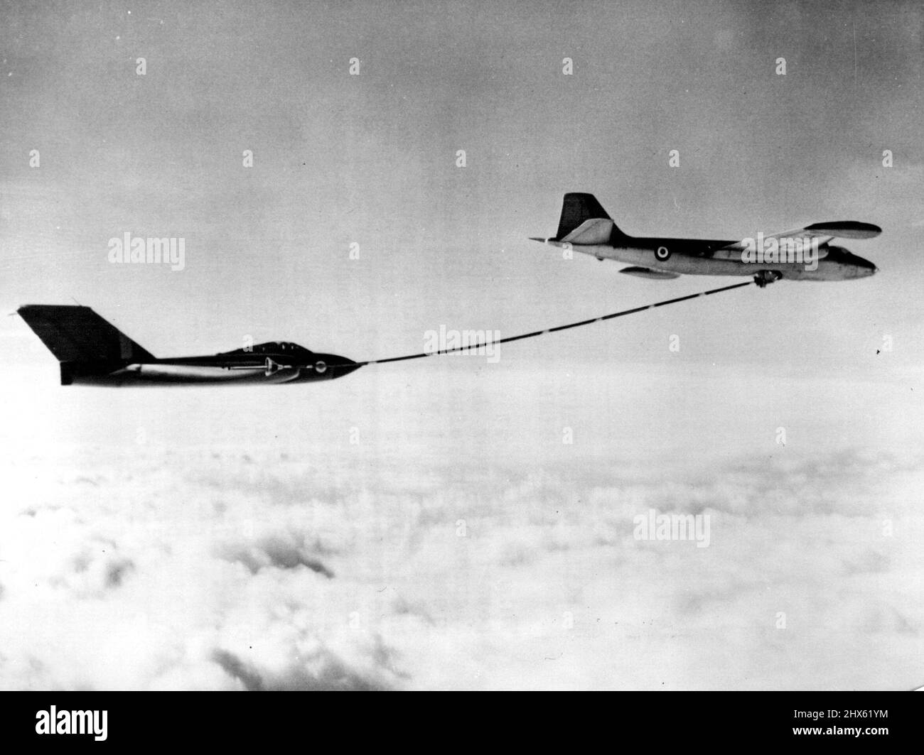 Le ravitaillement en vol donne à Javelin une gamme presque illimitée -- c'est la première photo publiée du puissant chasseur tout temps Gloster Javelin ravitaillé en vol à grande vitesse, offrant une portée presque illimitée. La Javelin est équipée d'une sonde sur le bord avant de son avion principal tribord et elle prend du carburant d'un bombardier anglais Electric Canberra MK B-1, équipé comme un pétrolier expérimental. Les deux avions sont équipés de l'équipement de « sonde » et « indésirable » conçu et produit Banque D'Images
