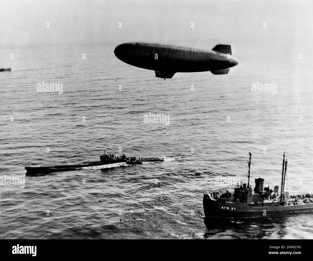 Le Nazi U-Boat arrive à la fin de Journey - Un navire de la marine américaine survole l'U-858, le premier sous-marin nazi à céder aux forces américaines après la capitulation de l'Allemagne, puisqu'il atteint un point de transfert désigné dans les eaux côtières de l'Atlantique le 14 mai 1945. À l'origine, le U-boat s'était rendu le 10 mai à l'une des deux escortes de destroyer de la flotte de l'Atlantique à 300 milles (482 km) au sud de Terre-Neuve. Ces escortes, toujours à côté de l'artisanat nazi, l'ont livré à un point au large de l'état de la côte est des États-Unis du New J Banque D'Images