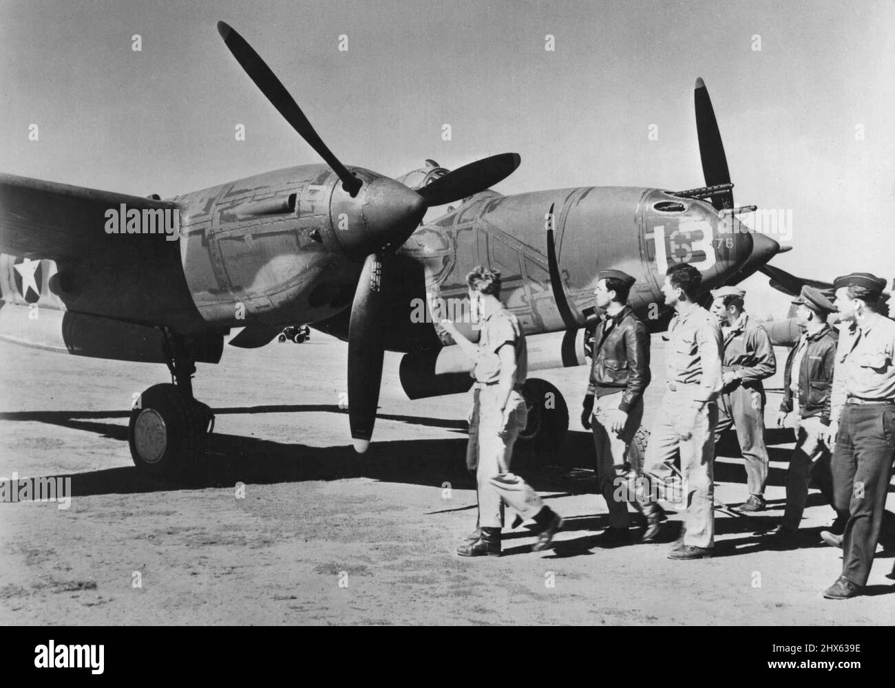 De nouveaux avions américains arrivent en Australie -- des pilotes de chasse américains inspectent un nouveau P-38 'Lightning', l'un des gros avions de chasse américains qui sont arrivés récemment en Australie. Les P-38, qui avaient déjà été en service contre l'axe en Europe et en Afrique, fondent leur force offensive sur (1) performances en haute altitude, (2) vitesse supérieure à 400 miles par heure et (3) puissance de feu forte, y compris les mitrailleuses lourdes et le canon automatique. 22 février 1943. (Photo par Interph Banque D'Images