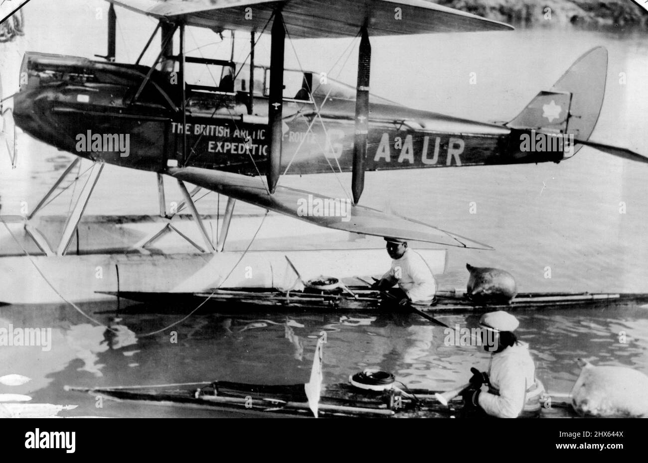 Expédition de la route aérienne de l'Arctique britannique : un des avions Moth sur des flotteurs, avec deux Eskimos dans leurs kayaks. 28 décembre 1931. (Photo par British Arctic Air route Expedition Photograph). Banque D'Images