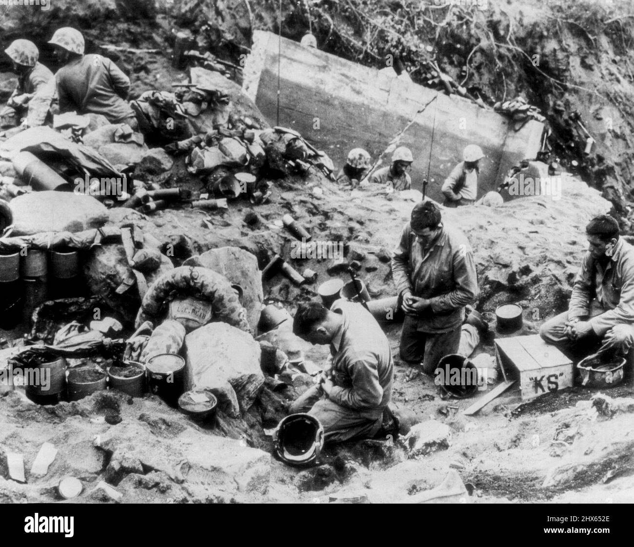 Marines Kneeli dans la prière pendant la tête dans les combats -- trois marines s'agenouillent dans la prière avant de recevoir la communion pendant une tête dans les combats pour la piste d'atterrissage de Motoyamo n° 1 sur Iwo Jima. PFC de gauche à droite. Edmond L. Fadel, Niagara Falls, N.Y.; Pvt. Walter Sokowski, Syracuse, New York, et Pvt. Nicholas A. Zingaro, Syracuse, N.Y., le 26 mars 1945. (Photo de Joe Rosenthal, AP Wirephoto). Banque D'Images