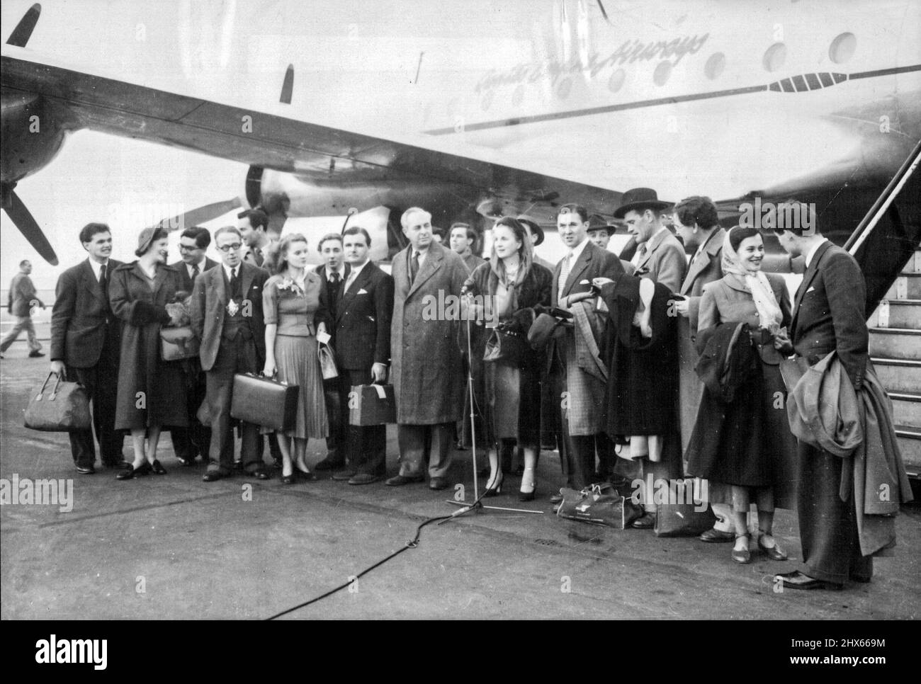 Shakespeariens Go by Air 14 Weeks Tour of Australia -- membres de la Shakespeare Memorial Company comme ils ont quitté l'aéroport de Londres, au micro est Miss Diana Wynyard, l'actrice. À gauche de Miss Wynyard se trouve le colonel Fordham Flower, président du Conseil des gouverneurs de la Société. Les membres de la Shakespeare Memorial Theatre Company de Stratford-on-Avon, dirigée par Diana Wynyard et Anthony Quayle, le directeur, ont quitté l'aéroport de Londres par B. O. A. C. -Qantas pour une visite de quatorze semaines au Banque D'Images