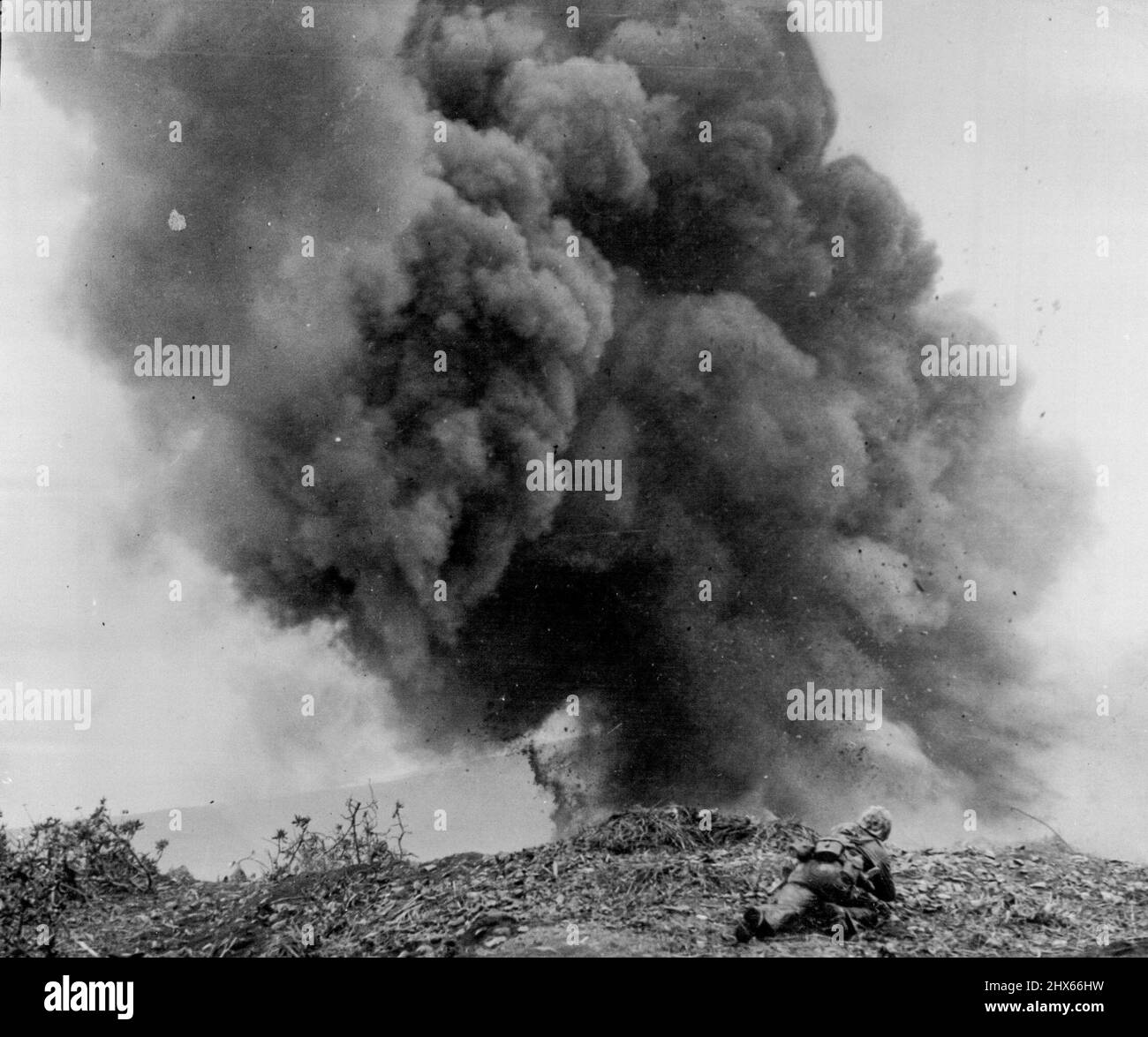 JAP Billbox a fait un blason sur Iwo Jima -- Un homme de démolition Marine embrasse le sol pour échapper aux débris volants après avoir mis en place une forte charge explosive pour faire exploser un pilbox japonais sur Iwo Jima. Après leur capture, bon nombre de ces positions ont dû être détruites de peur que l'ennemi ne retourne dans les abris et qu'il n'ouvre le feu sur les flancs de la Marine. 3 février 1945. (Photo par photo de presse associée). Banque D'Images