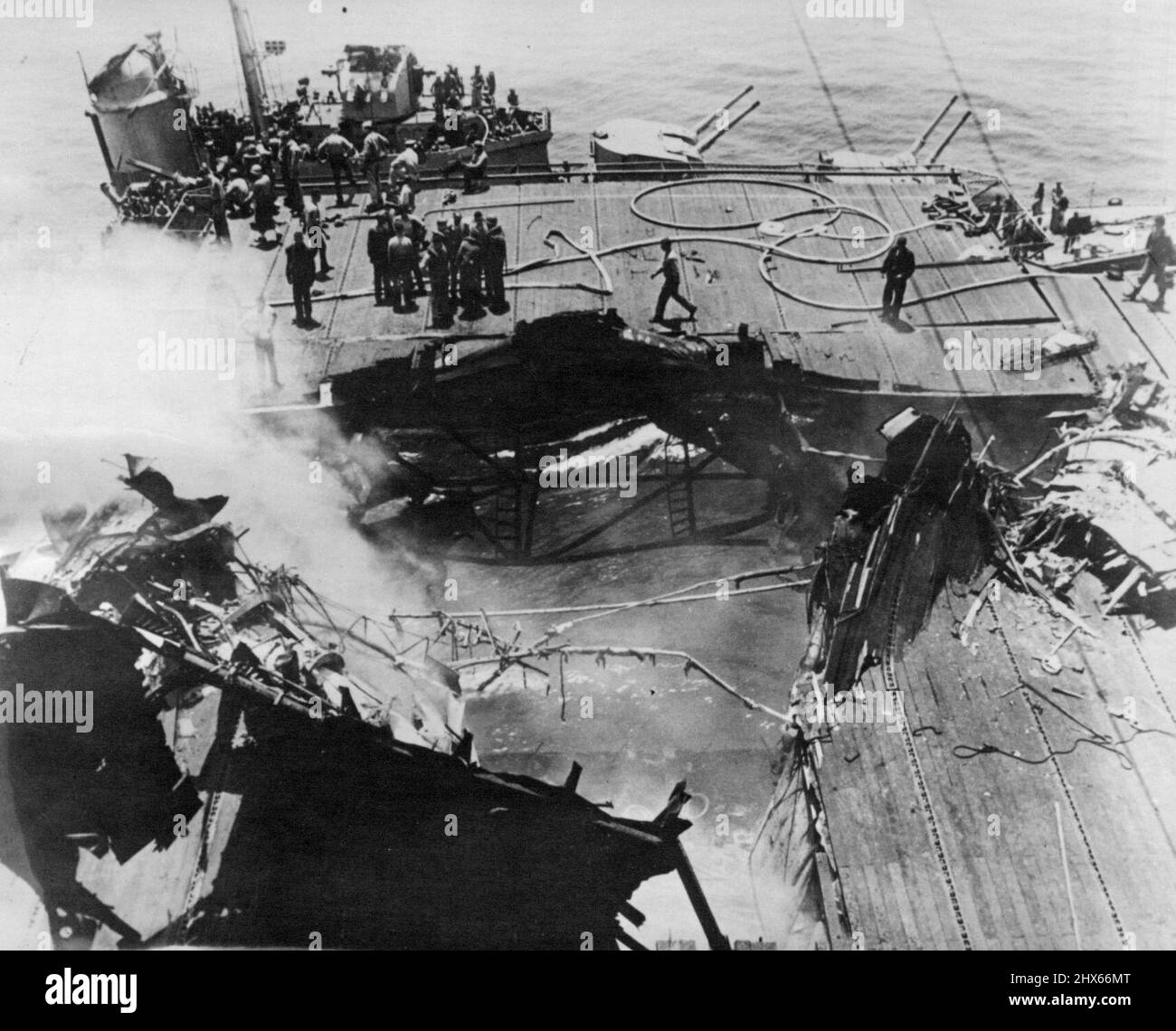 Une bombe de 500 kg, lancée par l'un des avions suicides avant qu'elle ne s'écrase sur le pont de vol, a frappé près de l'ascenseur situé au bord du pont et a pénétré dans la salle de préparation d'un pilote ci-dessous. La fumée continue de s'élever du trou béant laissé par la bombe qui a tué plusieurs pilotes du navire. 21 juin 1945. (Photo d'ACME). Banque D'Images