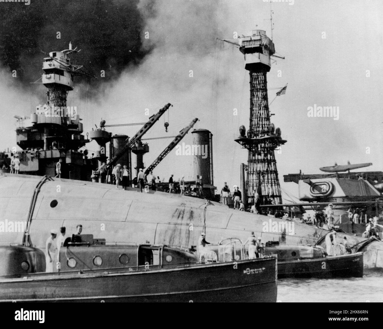 Les équipes de sauvetage ont travaillé sur la coque retournée du navire de guerre de 29 000 tonnes, U.S.S. Oklahoma, qui a chaviré à Pearl Harbor après avoir été attaqué par des avions Jap pendant le RAID de sneak, le 7th décembre dernier. Des trous ont été brûlés à travers la coque pour permettre le sauvetage de certains des hommes piégés en dessous. Notez l'un des lancements de l'Oklahoma au premier plan. En arrière-plan, est le cuirassé, U.S.S. Maryland, cette photo vient d'être publiée par le département de la marine à Washington. 4 février 1943. Banque D'Images