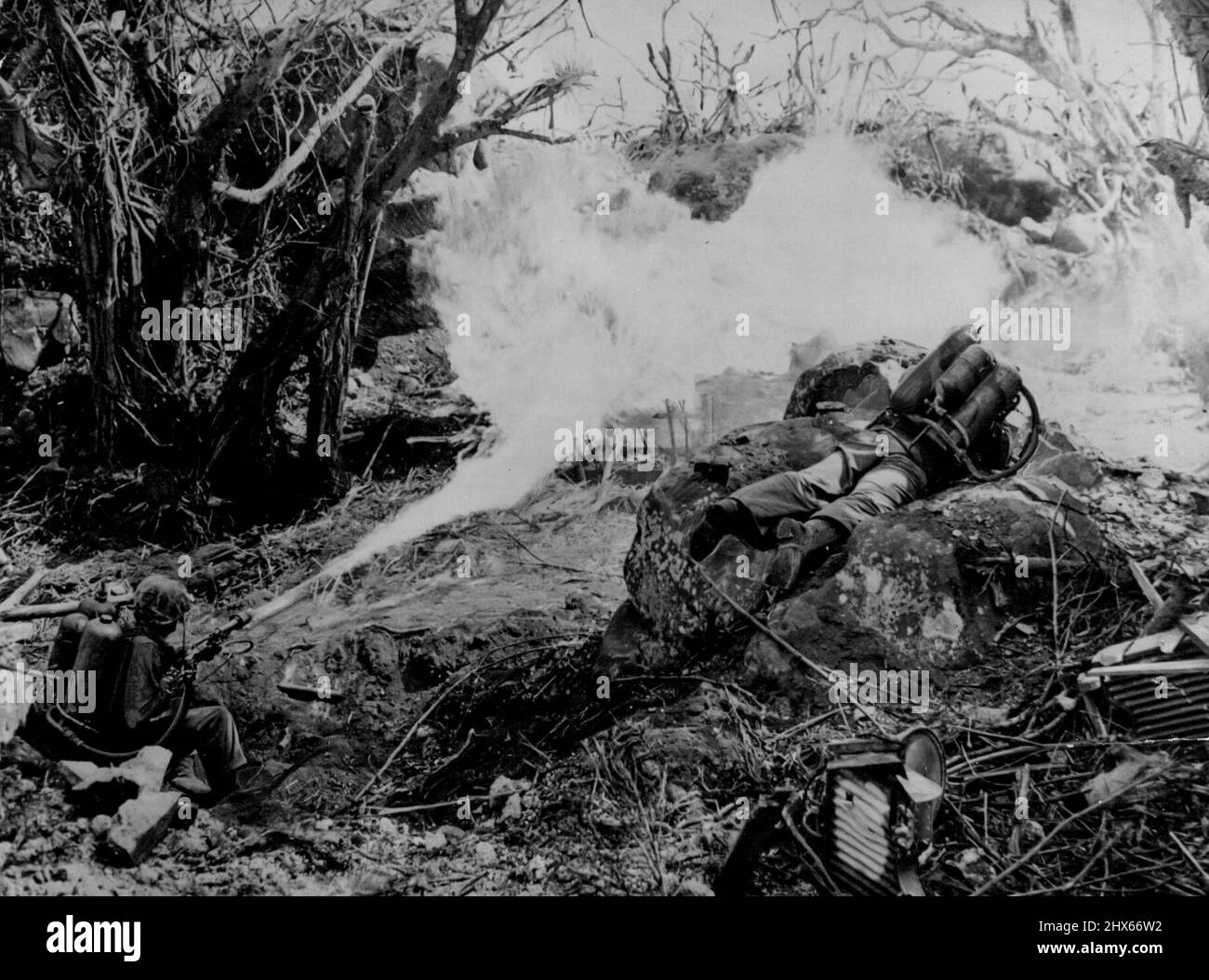Le souffle du diable sur l'île de l'Enfer -- deux soldats marins ont frappé le pont pour lancer un inferno brûlant aux défenses puissantes qui ont bloqué le chemin vers le Mont Suribachi d'Iwo Jima. De gauche à droite : le privé Richard Klatt, de North fond Dulac, Wisconsin, et le privé de première classe Wilfred Voegeli (dont la ville natale n'a pas été donnée). 14 mars 1945. (Photo par photo officielle du corps des Marines des États-Unis). Banque D'Images