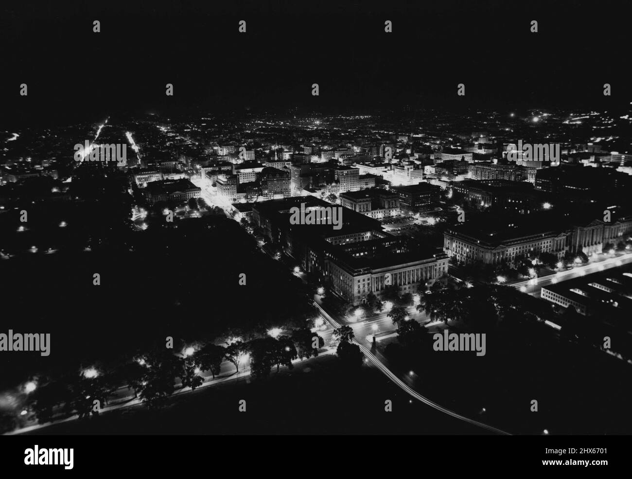 Vues de nuit de la capitale -- Voici une vue de nuit de la ville en regardant le nord-est depuis Washington Monument. Les deux grands bâtiments à droite sont le ministère du travail, à l'avant et le ministère des postes, à l'arrière. Le département du commerce est au premier plan du centre du bâtiment. Le premier bâtiment, à l'extrême gauche du centre, est la Maison Blanche. 4 juillet 1947. (Photo par Wide World photos). Banque D'Images