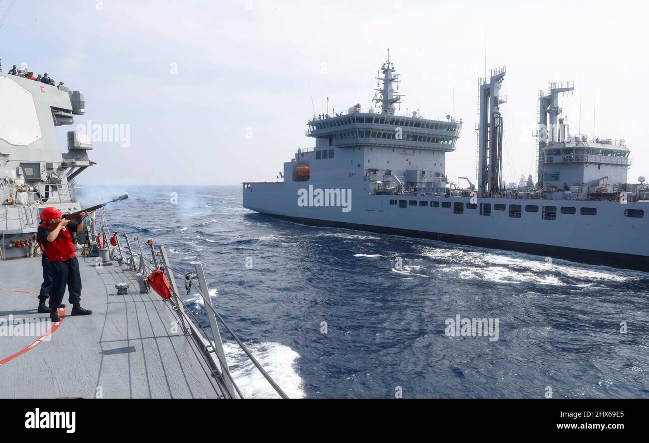 OCÉAN INDIEN (3 mars 2022) Gunner’s Mate 3rd Class Ethan Larsen, de Riverside, en Californie, tire la ligne de tir sur la balle du destroyer à missiles guidés de la classe Arleigh Burke USS Fitzgerald (DDG 62) vers le pétrolier de la classe Deepak INS Shakti (A57) pour un réapprovisionnement en mer pendant l’exercice de Milan 2022. L'exercice Milan 2022 est un exercice multilatéral biennal organisé par la Marine indienne auquel les États-Unis participent pour la première fois. L'exercice de cette année est axé sur l'amélioration de l'interaction professionnelle entre les marines professionnelles et sur l'acquisition d'expérience dans les opérations multilatérales des grandes forces à Banque D'Images