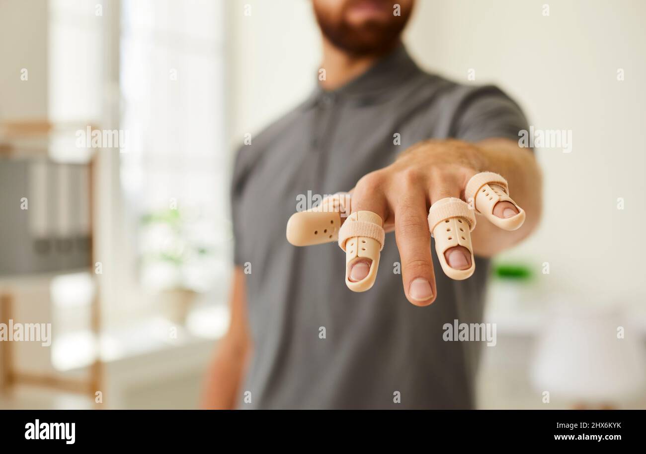Homme avec des doigts blessés portant des bretelles de attelles de soutien pour le traitement de la douleur et des blessures Banque D'Images