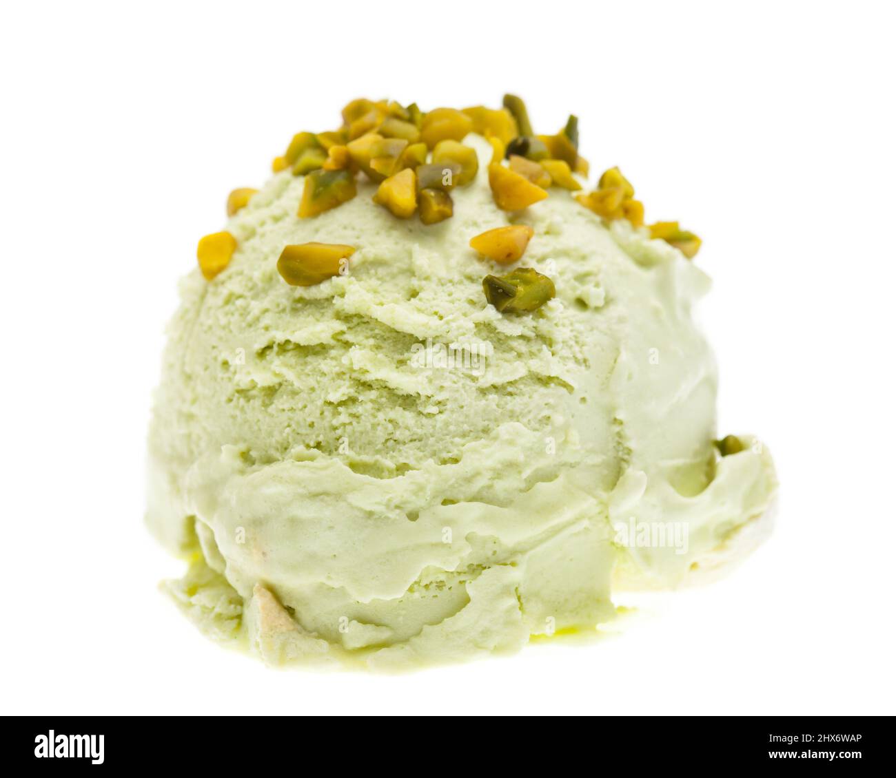 Une cuillère de glace à la pistache recouverte de morceaux de pistache isolés sur fond blanc Banque D'Images