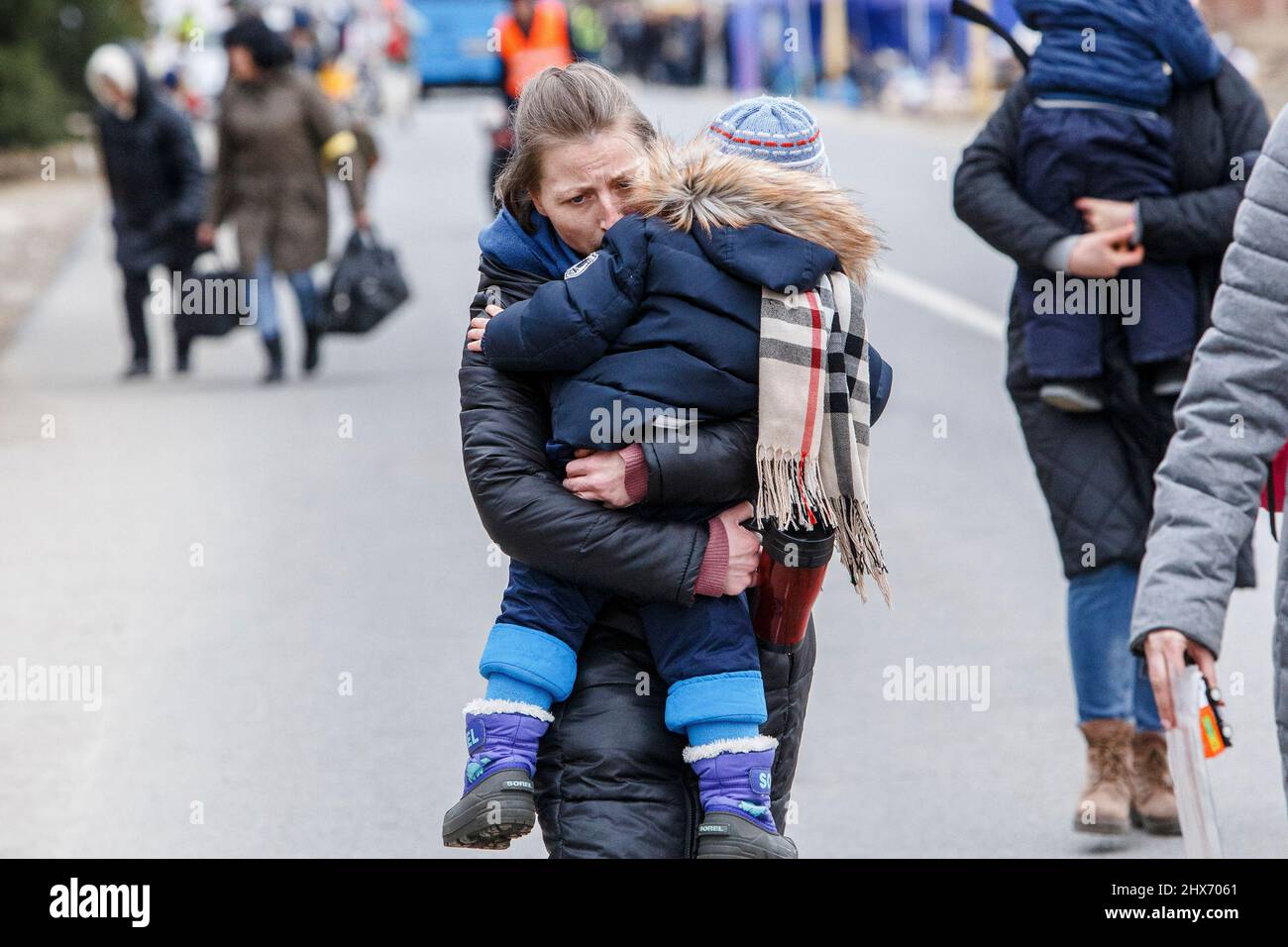 Non exclusif: UZHHORORD, UKRAINE - 09 MARS 2022 - Une femme porte un garçon dans ses armes lors de l'évacuation des réfugiés ukrainiens à travers l'Uzhgoro Banque D'Images