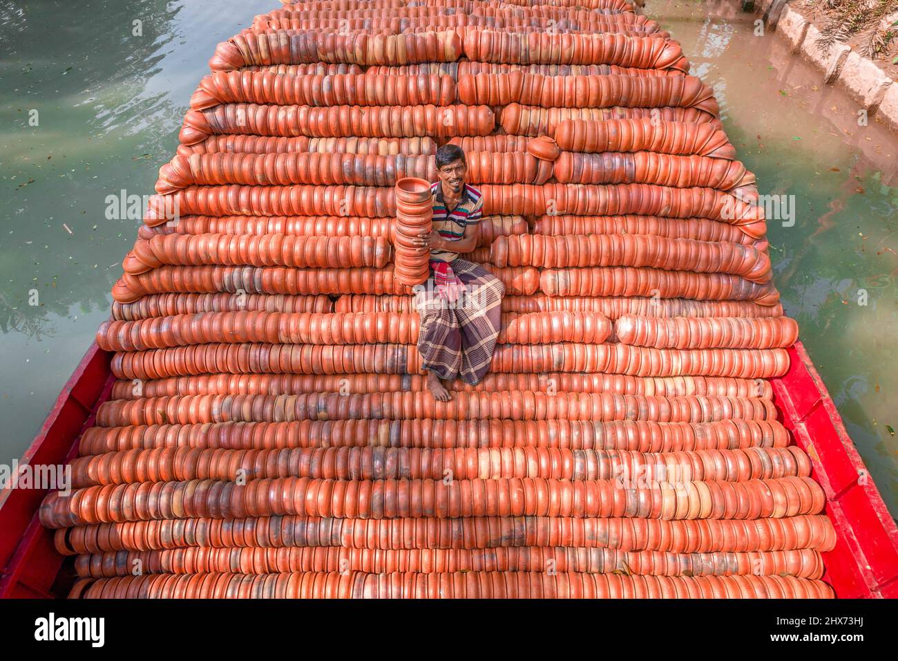 Barishal, Barishal, Bangladesh. 10th mars 2022. Les travailleurs chargent des milliers de poteries délicates sur un bateau pour qu'elles soient vendues sur les marchés locaux à travers le pays. Les photos sont prises dans la Division Barishal, dans la région sud du Bangladesh. Une équipe de travailleurs peut faire jusqu'à 25 000 pots faits main de plantes et de plaques chaque jour. C'est le seul endroit au Bangladesh où la poterie est transportée par bateau, comme la méthode habituelle est par camion. (Credit image: © Mustasinur Rahman Alvi/ZUMA Press Wire) Banque D'Images