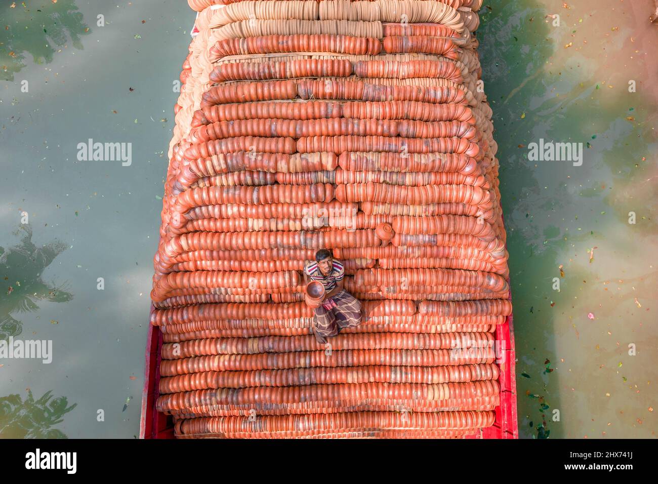 Barishal, Barishal, Bangladesh. 10th mars 2022. Les travailleurs chargent des milliers de poteries délicates sur un bateau pour qu'elles soient vendues sur les marchés locaux à travers le pays. Les photos sont prises dans la Division Barishal, dans la région sud du Bangladesh. Une équipe de travailleurs peut faire jusqu'à 25 000 pots faits main de plantes et de plaques chaque jour. C'est le seul endroit au Bangladesh où la poterie est transportée par bateau, comme la méthode habituelle est par camion. (Credit image: © Mustasinur Rahman Alvi/ZUMA Press Wire) Banque D'Images