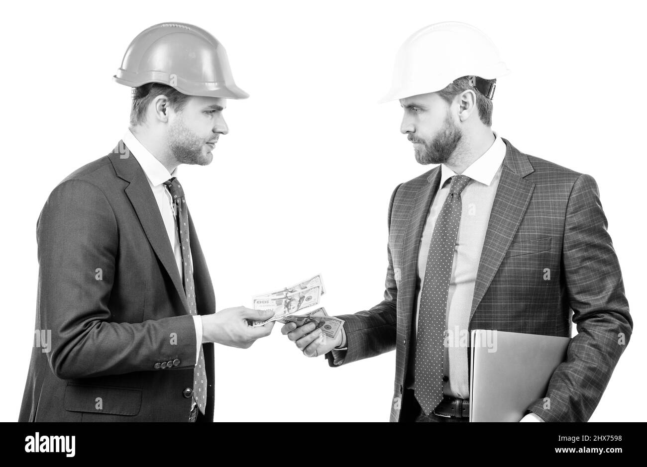 investisseurs hommes en costume et casque de sécurité donnant ou prenant de l'argent et de tenir l'ordinateur, l'investissement Banque D'Images