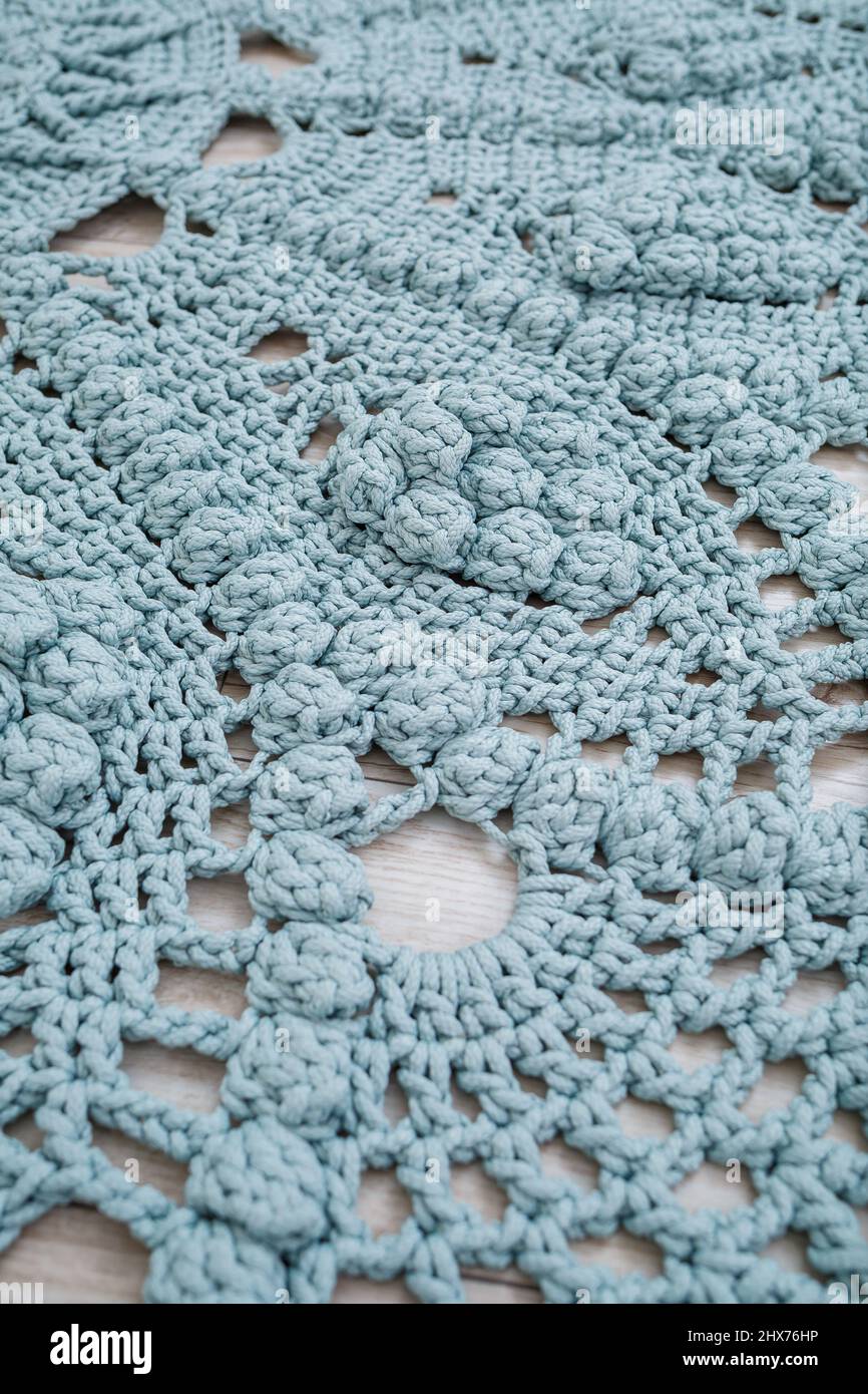 Tapis maison tricoté de fils épais, fait à la main: Un tapis fait à la main de fils bleus se trouve sur le sol, l'art du tricotage Banque D'Images