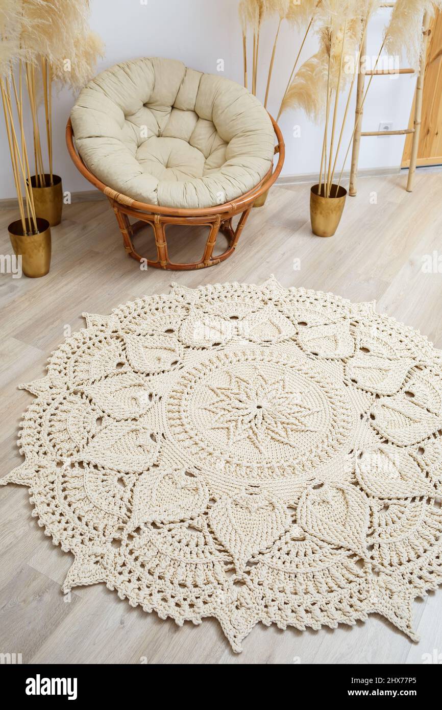 Tapis fait maison en fils épais, fait à la main: Un tapis fait à la main en  fils beige se trouve dans le salon près du fauteuil, l'art de Knitt Photo  Stock -