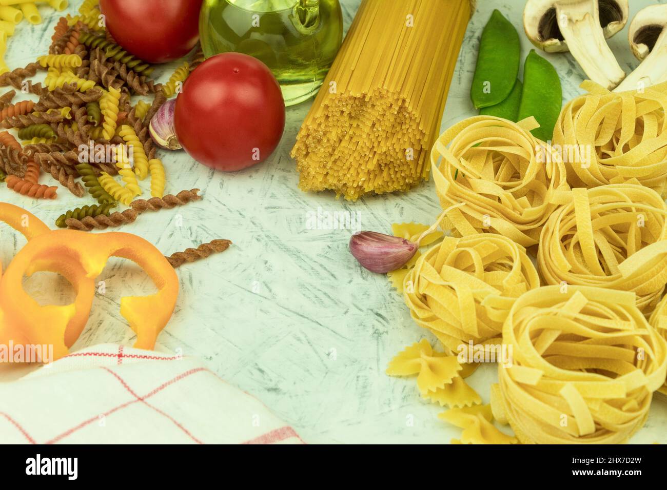 Divers types de pâtes sur la table. Divers types de pâtes et de nouilles crues avec légumes. Concept culinaire de la cuisine italienne. Collection Banque D'Images