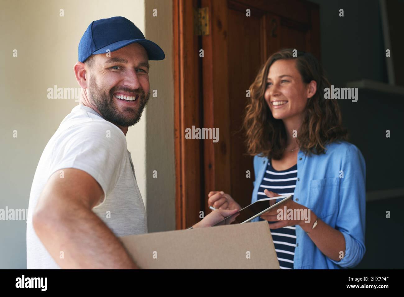 Une autre livraison est remise à un client satisfait. Portrait d'un messager qui effectue une livraison à une cliente à son domicile. Banque D'Images