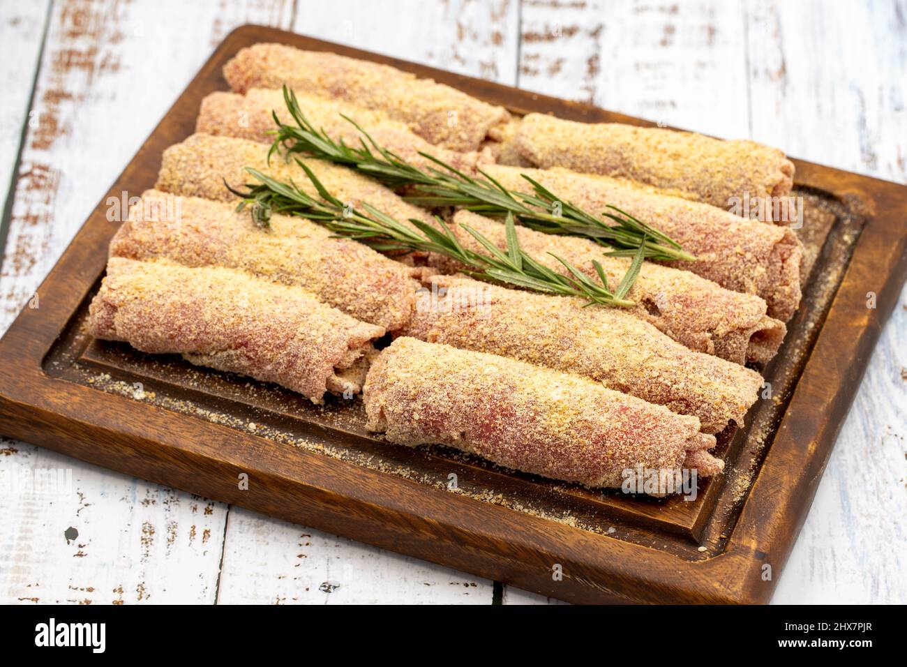 Schnitzel de bœuf sur fond de bois. Délicieux schnitzel de viande crue préparé avec de la chapelure et du sésame blanc. Banque D'Images