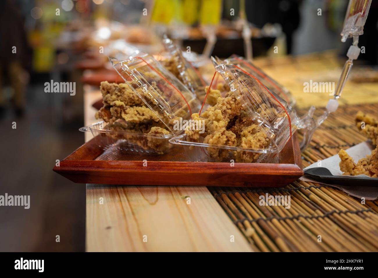 Le Karaage ou le poulet frit de style japonais est emballé dans un contenant en plastique et à la vente - cuisine japonaise de rue. Banque D'Images