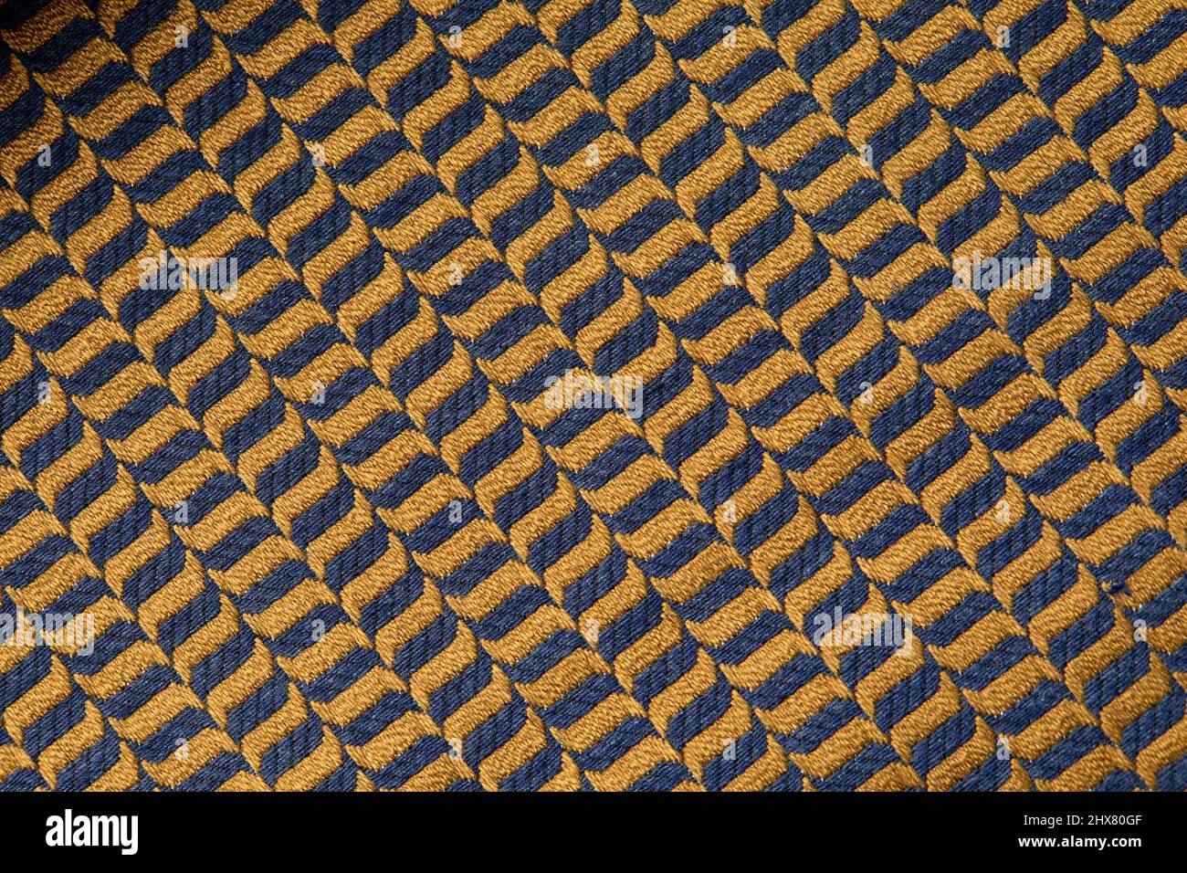 tissu de couleur moutarde avec motifs géométriques. texture tricotée moutarde, couleur moutarde de fond tricoté. Banque D'Images