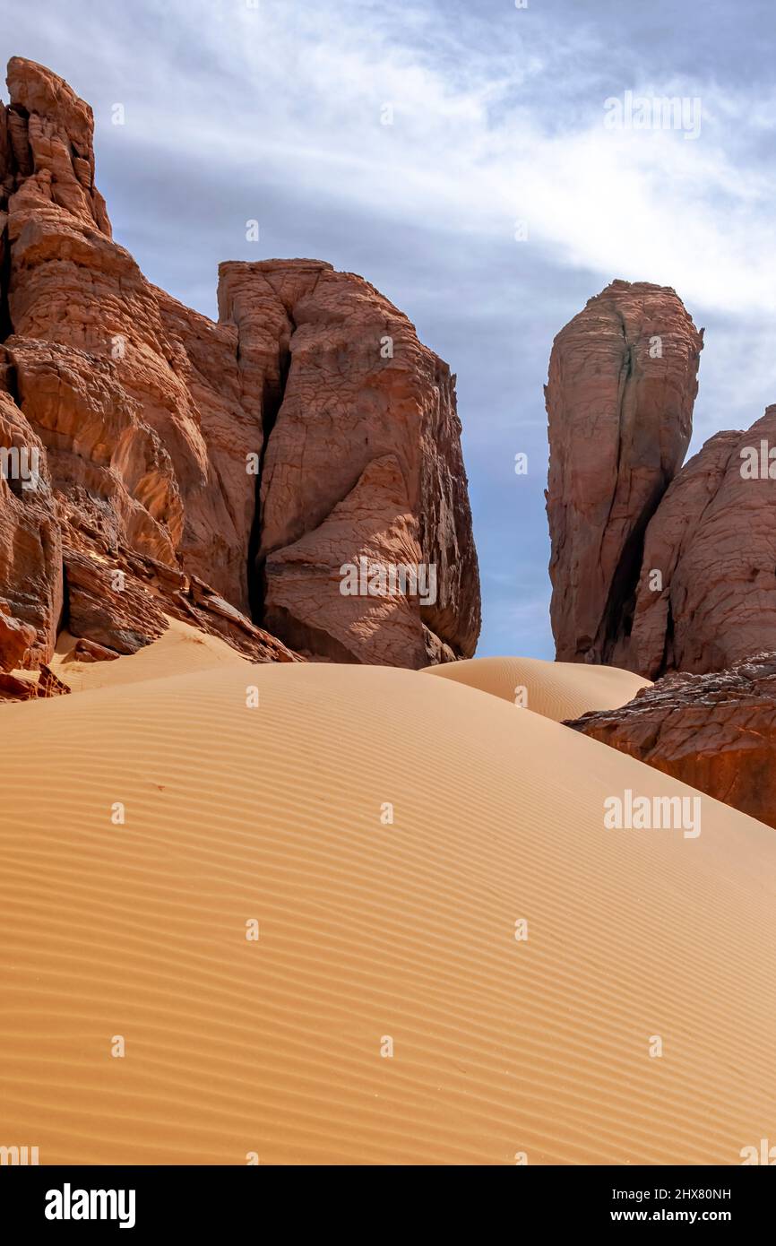 Porte en pierre naturelle vue à angle bas perspective d'une dune de sable et de montagnes rocheuses donnant l'illusion d'une porte dans le désert du sahara de Tadrarart rouge. Banque D'Images