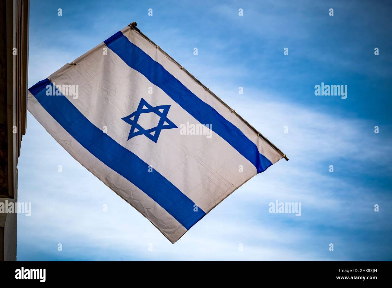 Drapeau israélien contre ciel bleu et nuages blancs Banque D'Images