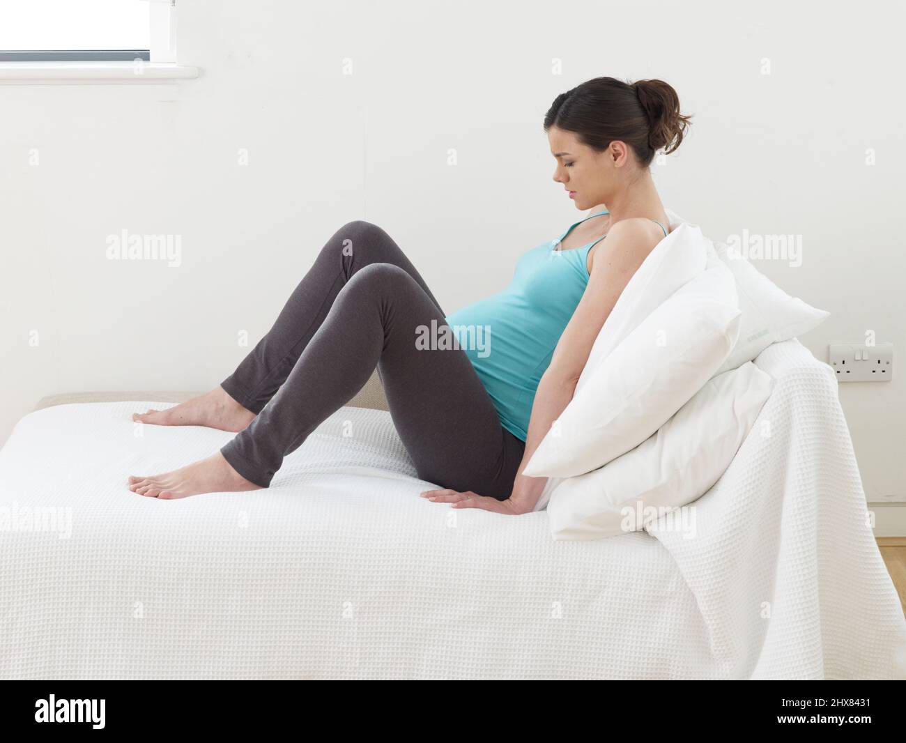Femme enceinte assise sur un canapé recouvert de drap pendant le travail à  la naissance Photo Stock - Alamy