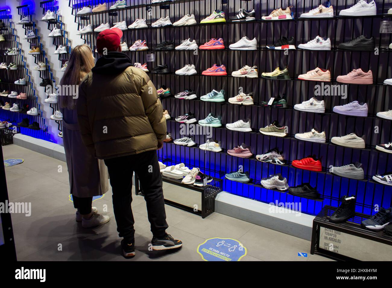 Les amateurs de shopping sélectionnent des baskets dans une boutique Adidas  à Moscou. Adidas devrait cesser toutes les ventes en ligne et hors ligne en  Russie d'ici le 13 mars 2022, à