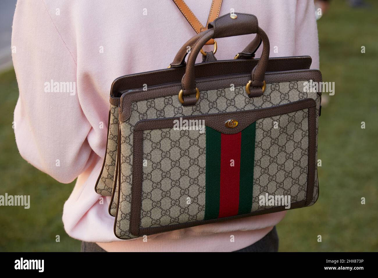 MILAN, ITALIE - 23 FÉVRIER 2022: Homme avec sac Gucci, sac à dos et chandail rose avant Fendi défilé de mode, Milan Fashion week Street style Banque D'Images