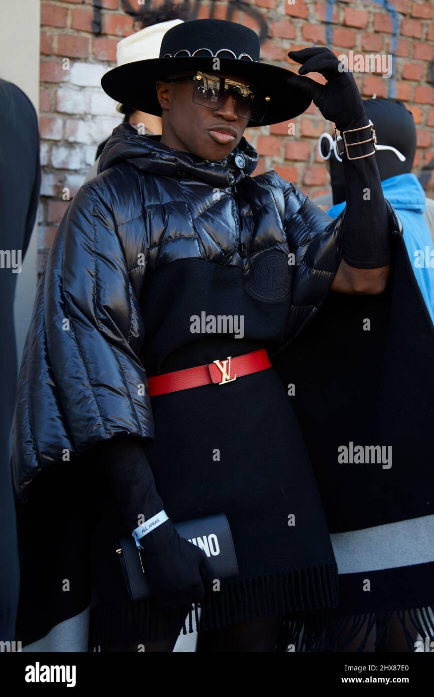 MILAN, ITALIE - 23 FÉVRIER 2022 : homme avec veste Moncler noire, ceinture Louis Vuitton rouge et sac Moschino avant le spectacle de mode de Fendi, semaine de la mode de Milan Banque D'Images