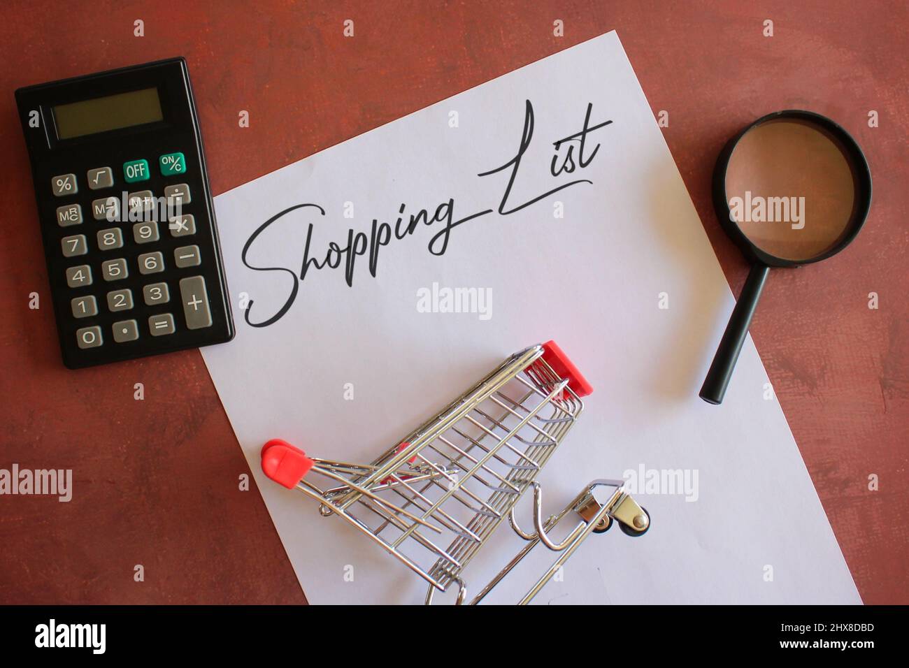 Calculatrice, panier, loupe et papier avec liste d'ACHATS de texte. Copier l'espace pour le texte. Banque D'Images