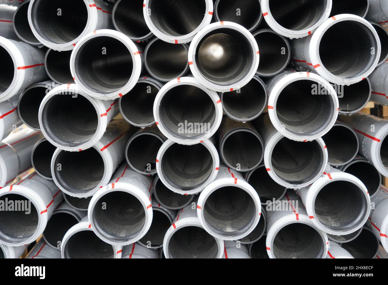 Tuyaux, tubes ou pipelines en plastique en coupe transversale comme arrière-plan stockés dans un faisceau. Ils sont fabriqués dans un matériau durable et sont utilisés dans la construction. Banque D'Images