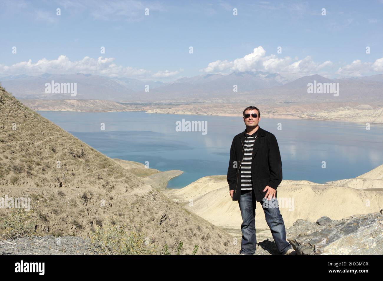Portrait de l'homme sur le fond du réservoir de Toktogul, situé dans la province de Jalal-Abad au Kirghizistan, est le plus grand des réservoirs sur le chemin du Th Banque D'Images