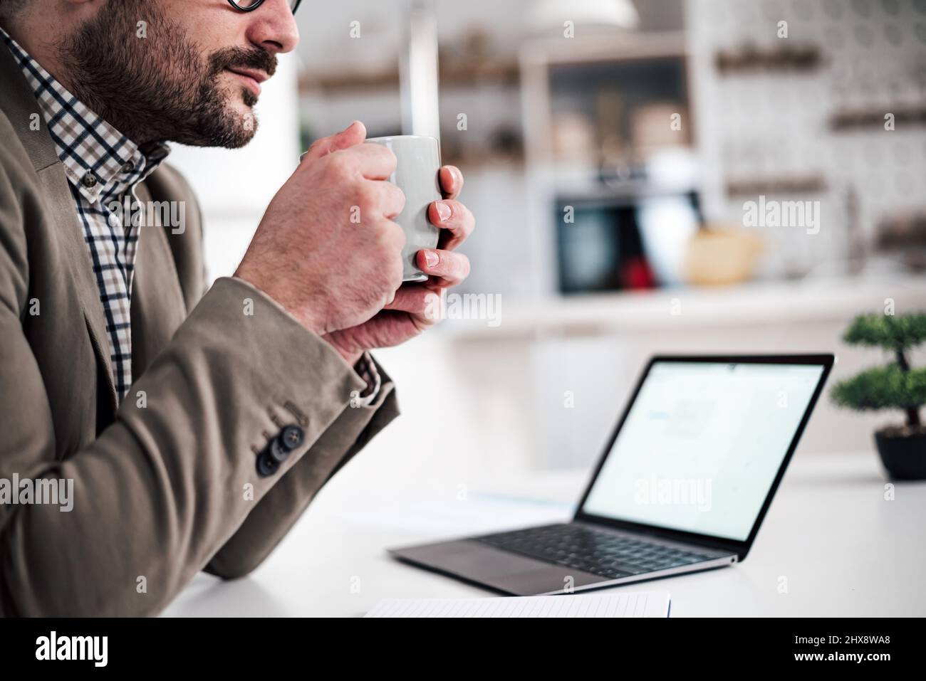 Coupe supérieure moitié de la section médiane de l'adulte jeune homme appréciant, tenant une tasse de café, thé ou autre boisson tout en prenant une pause de travail. Banque D'Images