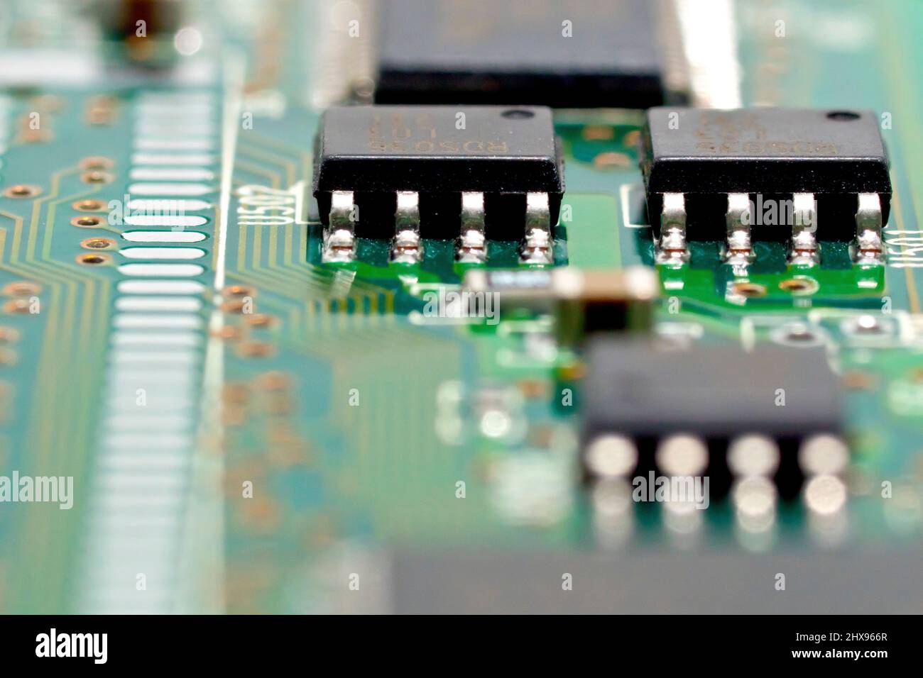 Gros plan sur une carte de circuit imprimé, en mettant l'accent sur deux puces intégrées connectées aux circuits imprimés d'une carte de circuit imprimé. Banque D'Images