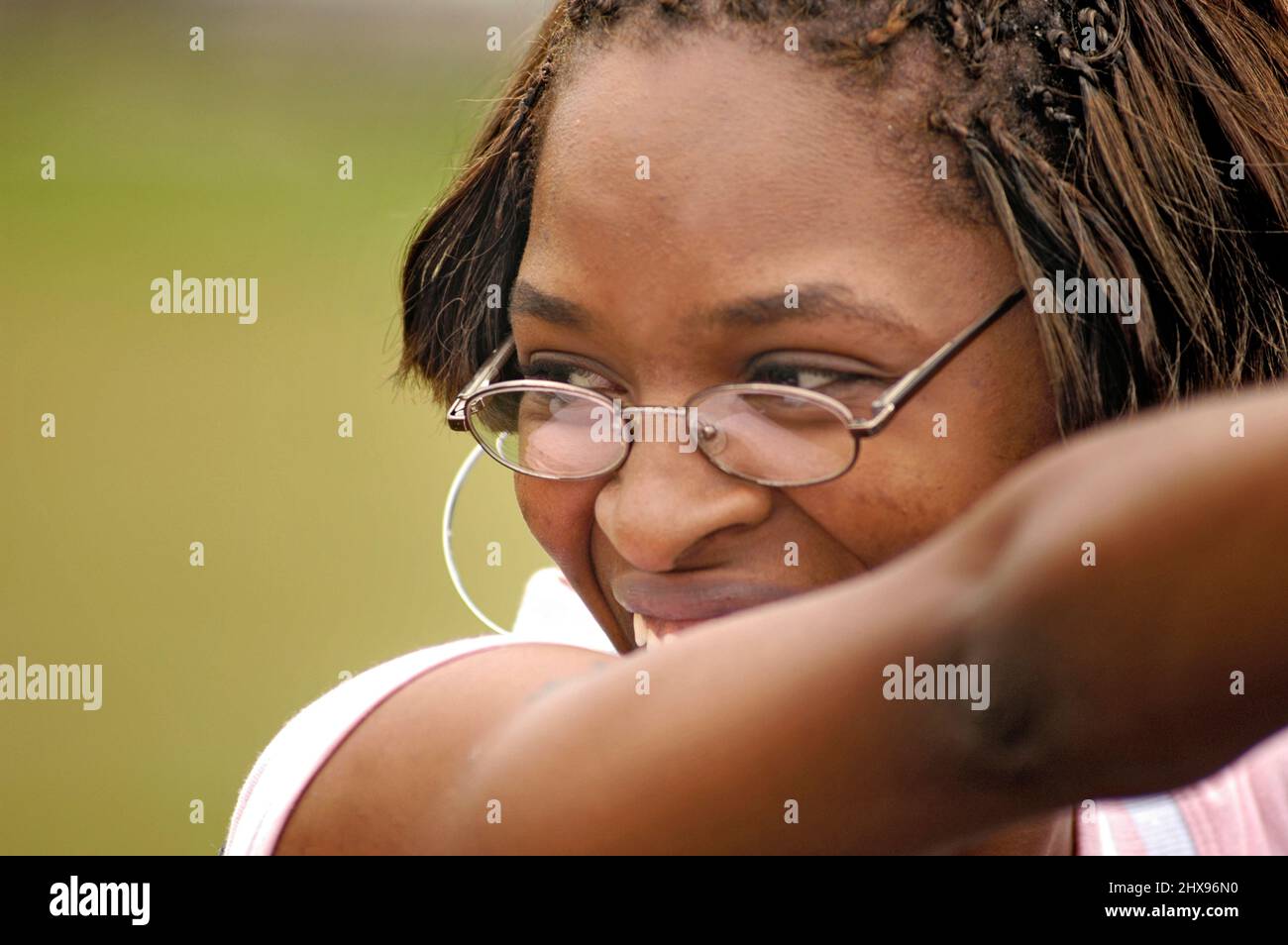 Visage de jeune femme souriante ethnique avec des verres à rebord en acier et des cheveux de ligne de maïs et de l'espace pour le texte ou la copie Banque D'Images