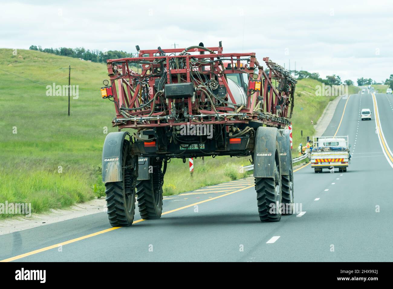Un véhicule agricole, un pulvérisateur, une machine agricole se déplace le long d'une autoroute dans l'État libre, en Afrique du Sud, dans une zone agricole rurale Banque D'Images