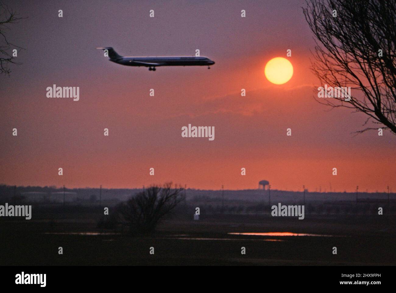 Un avion d'American Airlines débarquant à l'aéroport DFW au coucher du soleil vers. 1997 Banque D'Images