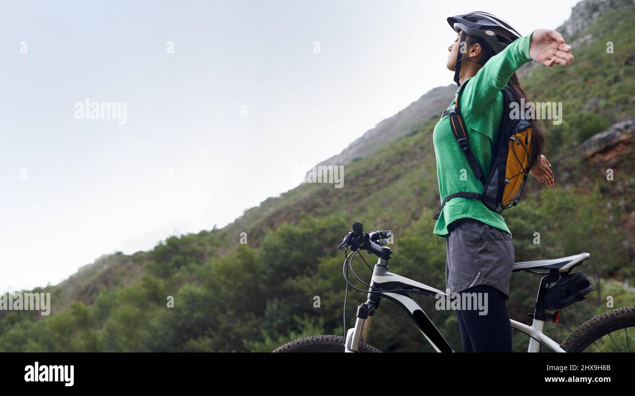 Je me sens si libre. Une jolie jeune femme VTT dans un cadre pittoresque. Banque D'Images